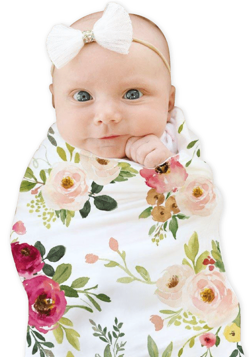 Beautiful baby girl wearing a floral swaddle with a matching white ribbon headband